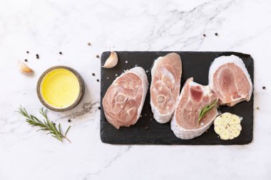 Raw meat steaks for grilling. Steaks raw turkey with spices on a marble tabletop. Top view flat lay background. 