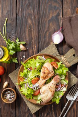 Grilled chicken meat with fresh green lettuce, cucumbers, tomato and red onion. Ketogenic, keto or paleo diet lunch. Top view flat lay. Copy space.