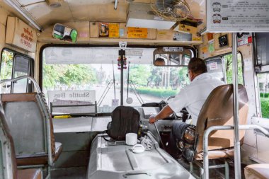 BANGKOK THAILAND - 26 Temmuz 2017: Tay otobüs şoförü arka planda kontrol koltuğunda. Covid-19 salgınından önce yaz havasında Bangkok Tayland toplu taşımacılığı.