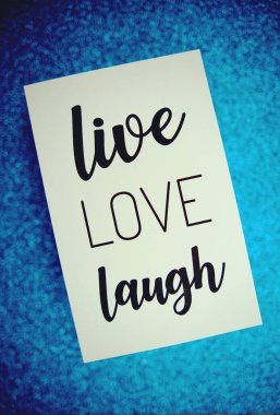 Live Love Laugh metin üzerinde kağıt kart üst görünüm mavi bokeh arkaplan