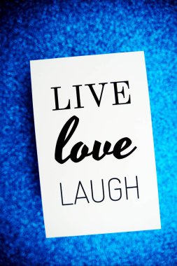 Live Love Laugh metin üzerinde kağıt kart üst görünüm mavi bokeh arkaplan