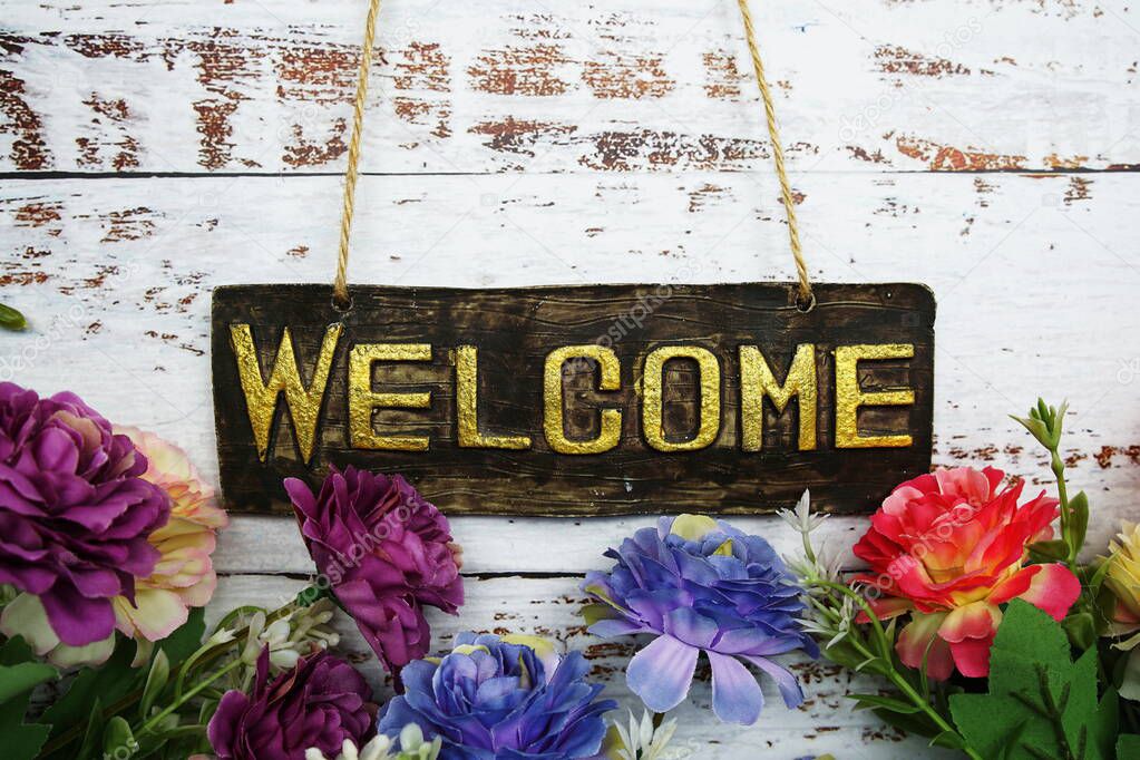 Welcome Sign with flowers frame decorate on wooden background