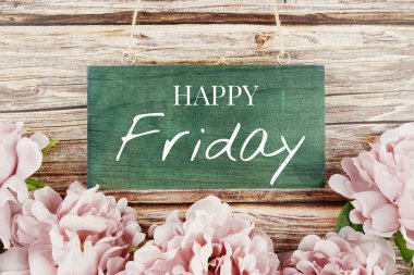 Tahta arka planda pembe çiçek buketi olan mutlu cuma tipografisi metinleri