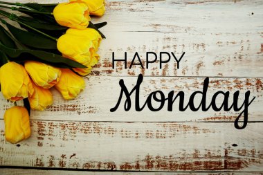 Mutlu Pazartesi metinleri ve beyaz ahşap arka planda sarı laleler.