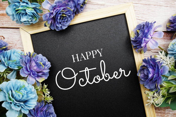 Happy October text on blackground decorated with flower bouquet on wooden background