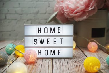 Home Sweet Home metni ahşap arka planda ışık kutusu üzerine