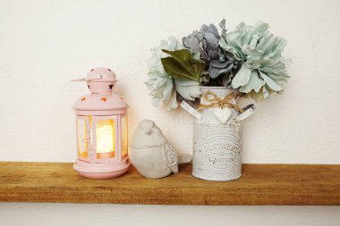 Eyfel kulesi hatırası, mum ışığı, çiçek buketi ve kuş heykeliyle süslenmiş ahşap raflar.