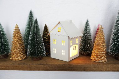 Ev feneri ve Noel ağacı ahşap raflarda süslenir.