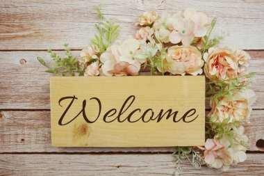 Hoş geldiniz. Ahşap arkaplanda çiçek çerçeveli imza.