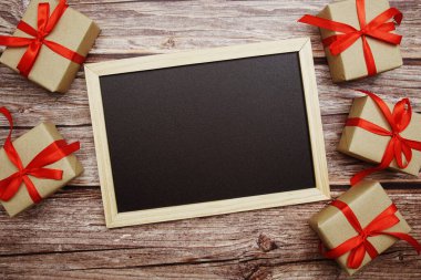 Ahşap zemin üzerinde hediye kutusu olan boş karatahta