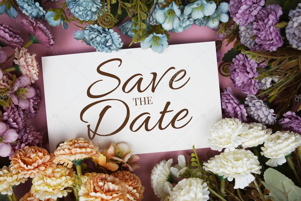 Save the Date typography text with flowers frame on pink background