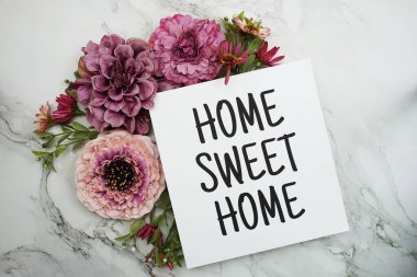 Mermer arka planda pembe çiçek buketi olan Home Sweet Home metni