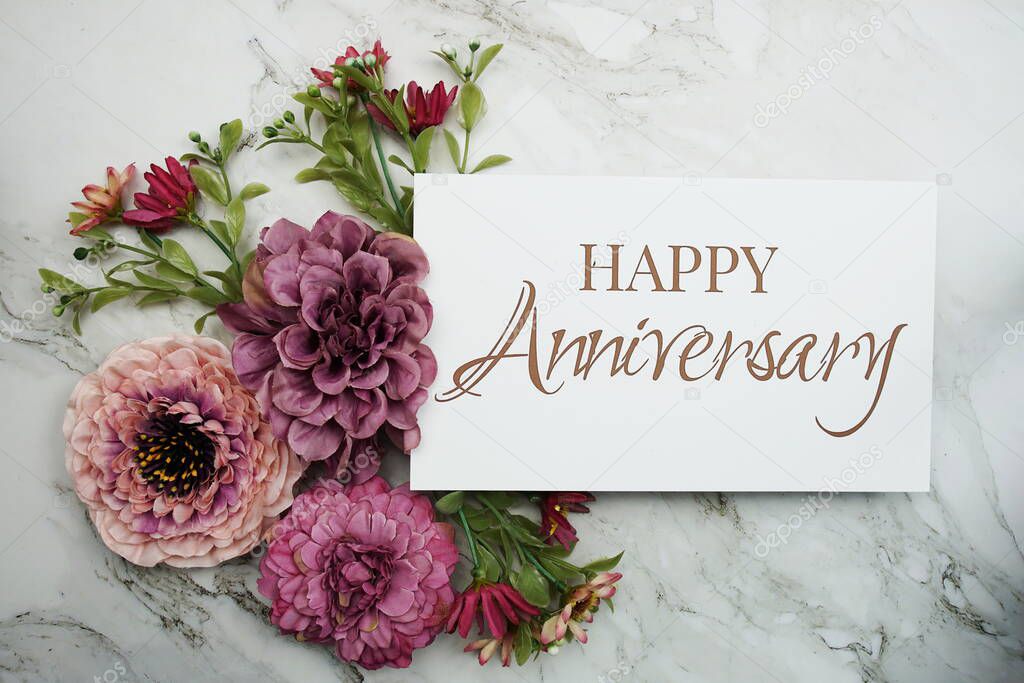 Happy Anniversary with pink flower bouquet on marble background