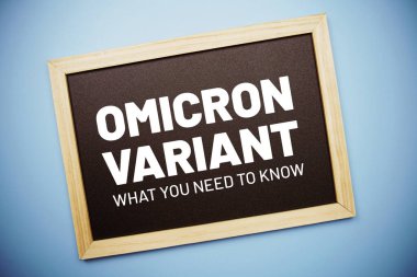 Tahta düz üzerinde Omicron Varyant metin mavi arkaplan üzerinde yatıyordu