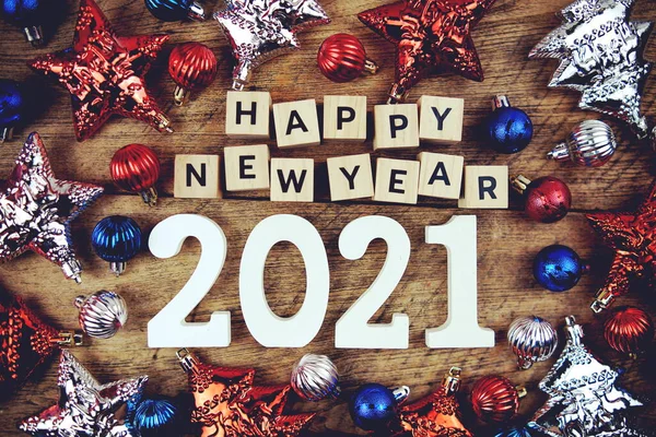 Yeni yılınız kutlu olsun. Yeni yıl alfabesi harfleri ve ahşap arka planda Noel süsleri.