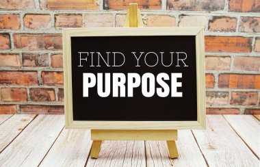Find Your Purpose typography text on the blackboard set on wooden floor and brick background