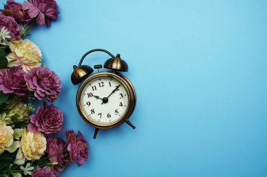 Mavi arkaplanda çiçek çerçeveli alarmlı saat