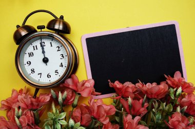 Sarı arkaplanda çiçek çerçeveli alarm saati