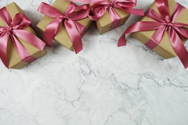 Mermer arka planda pembe kurdeleli hediye kutuları