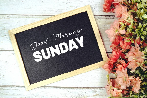 Good Morning Sunday texton blackboard with flower bouquet decoration