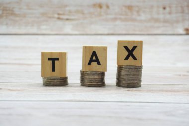 Tahta zemin üzerinde bozuk paralar olan vergi alfabesi harfleri