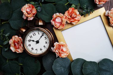 Çalar saat, çiçek ve okaliptüs içeren boş alan ahşap arka planda dekorasyon bırakır