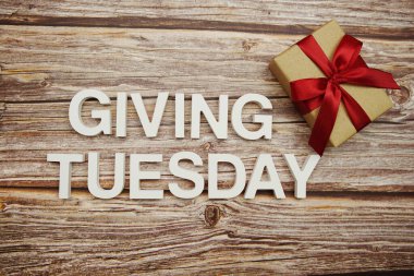 Tahta arka planda Salı alfabesi harfleri ve hediye kutusu vermek.