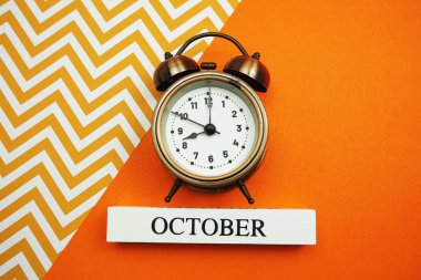 Turuncu arka planda Ekim ve Alarm saati