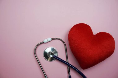 Pembe arka planda uzay kopyası olan Kalp ve Stetoskop