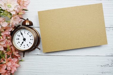 Tahta zemin üzerinde pembe papatya çiçeği bezi olan boş bir kağıt kart.