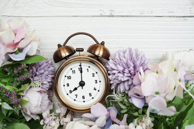 Çiçek buketi düzlüklü çalar saat ahşap zemin üzerinde yatıyordu