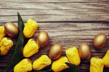 Ahşap arka planda yumurta ve lale çiçekli Paskalya arkaplanı