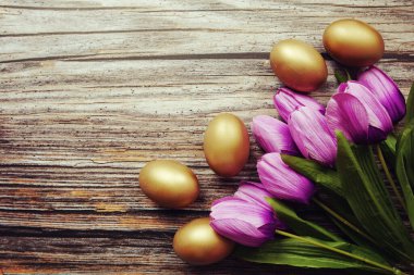 Ahşap arka planda yumurta ve lale çiçekli Paskalya arkaplanı