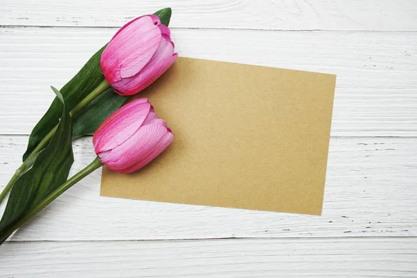 粉色郁金香花平铺在木制背景上的空白卡片 — 图库照片