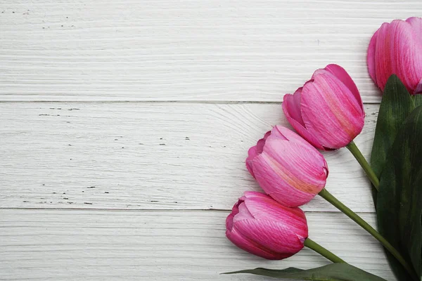 Ahşap kaplamalı pembe lale çiçeği buketi.