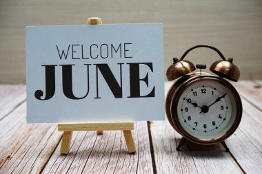 Ahşap arka planda alarmlı Haziran mesajına hoşgeldiniz