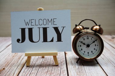 Ahşap arka planda alarmlı Temmuz mesajına hoşgeldiniz