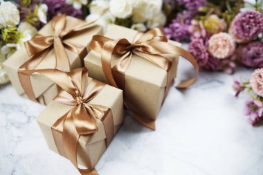 Hediye kutuları ve çiçek buketi mermer arka planda yer kopyası
