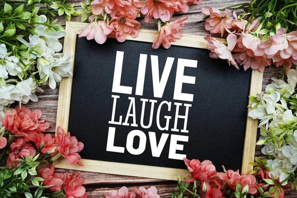 Canlı Kahkaha Aşk tipografisi Tahta tahtaya yazılmış Tahta arka planda çiçek buketi süslemesi