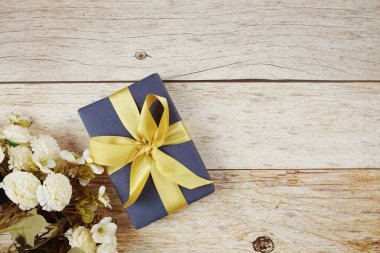 Ahşap arka planda pembe kurdeleli hediye kutusu