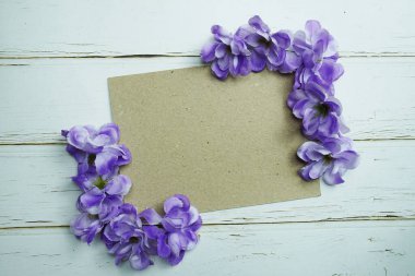 Ahşap zemin üzerinde çiçek buketi olan boş kağıt işçiliği