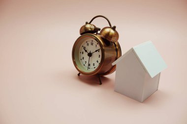 Alarm saati ve ev modeli pembe arkaplanda boşluk kopyası