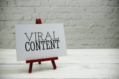 Beyaz tuğla duvarda ve tahta zeminde viral içerik metni