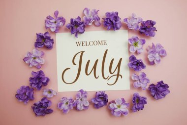 Welcome July card typography text with flower bouquet on pink background