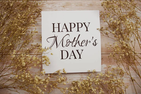 纸卡片上的母亲节快乐文字 木制背景上装饰着花朵 — 图库照片