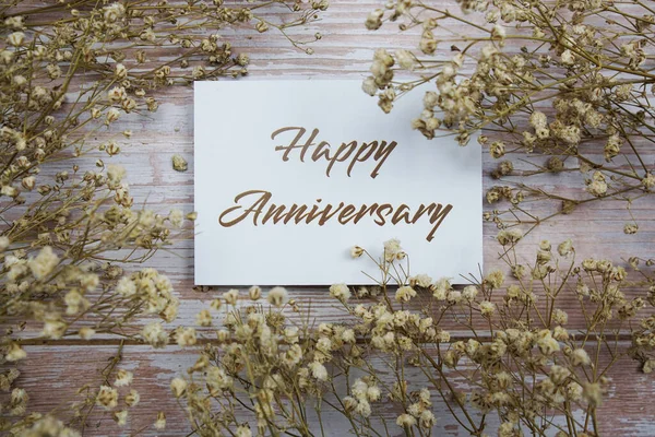 Happy Anniversary Text Paper Card Flower Decoration Wooden Background — Stock Photo, Image