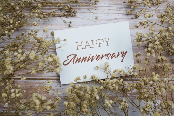 Šťastné Výročí Text Papírové Kartě Květinovou Výzdobou Dřevěném Pozadí — Stock fotografie