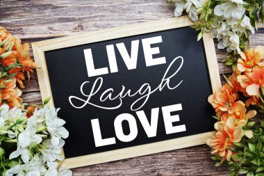 Canlı Kahkaha Aşk tipografisi Tahta tahtaya yazılmış Tahta arka planda çiçek buketi süslemesi