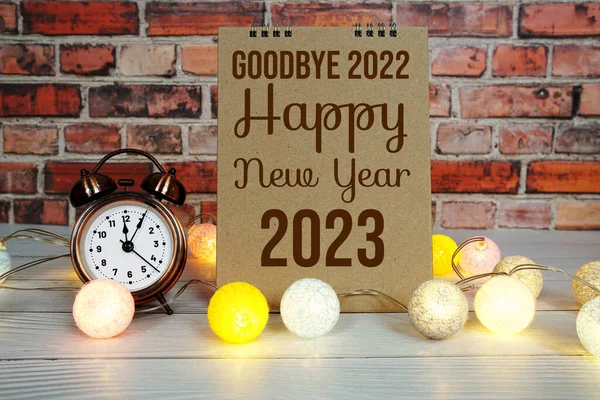 Happy New Year 2023 text message with alarm clock and LED cotton balls decoration