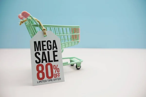 Mega Sale 80% off text message on price tax with shoppint trolley cart on blue and pink background